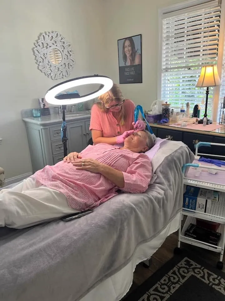 The facial room set up with treatment bed and ring light