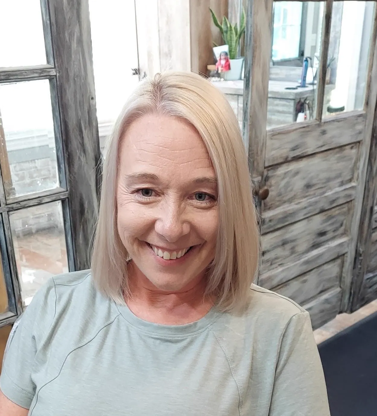 Client smiling with a fresh blonde bob haircut at Kozo Salon & Spa